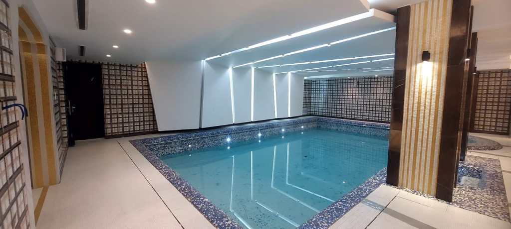 Indoor swimming pool with modern design, blue water, and relaxing atmosphere – pool construction example
