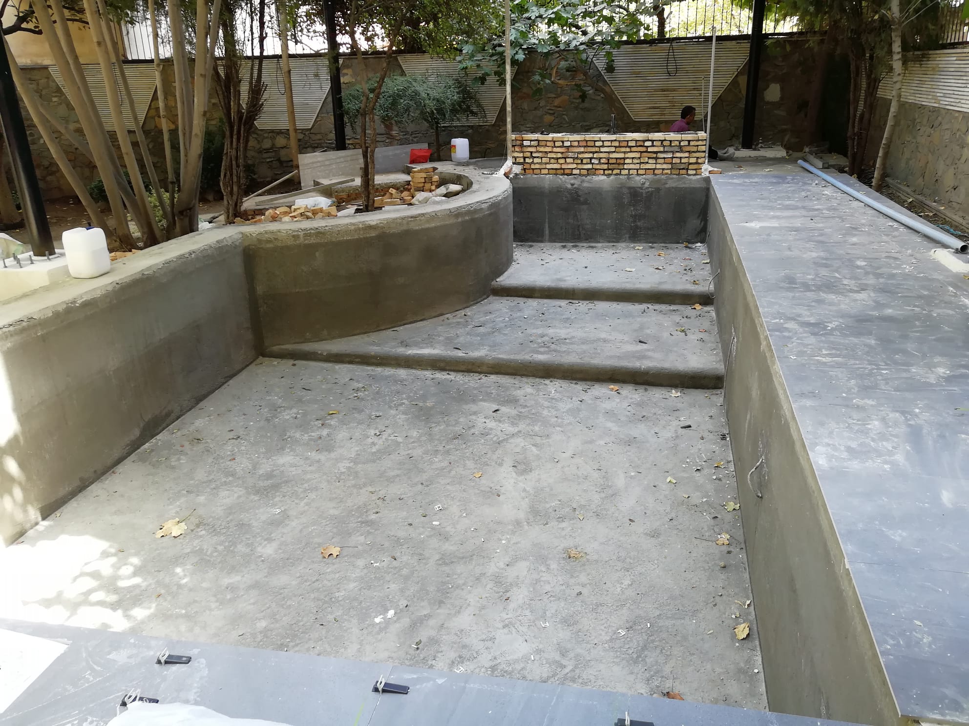 Before and after outdoor swimming pool construction showing the transformation from raw concrete structure to a finished modern pool with landscaping.