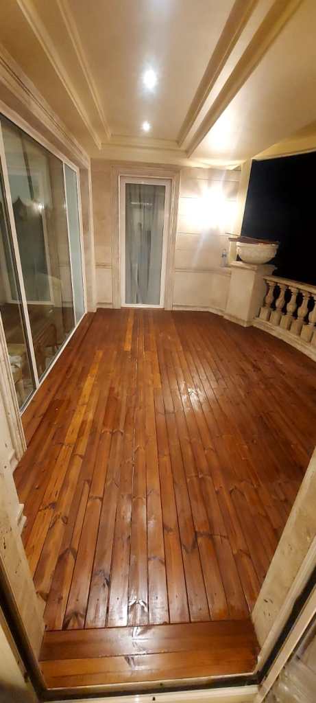 Finished modern balcony with stylish wooden flooring, perfect for outdoor relaxation