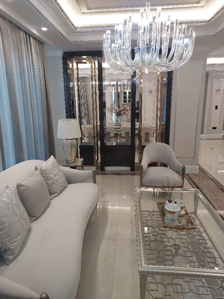 Elegant living room design featuring a modern chandelier, plush sofa, and sleek coffee table for a cozy and luxurious interior.