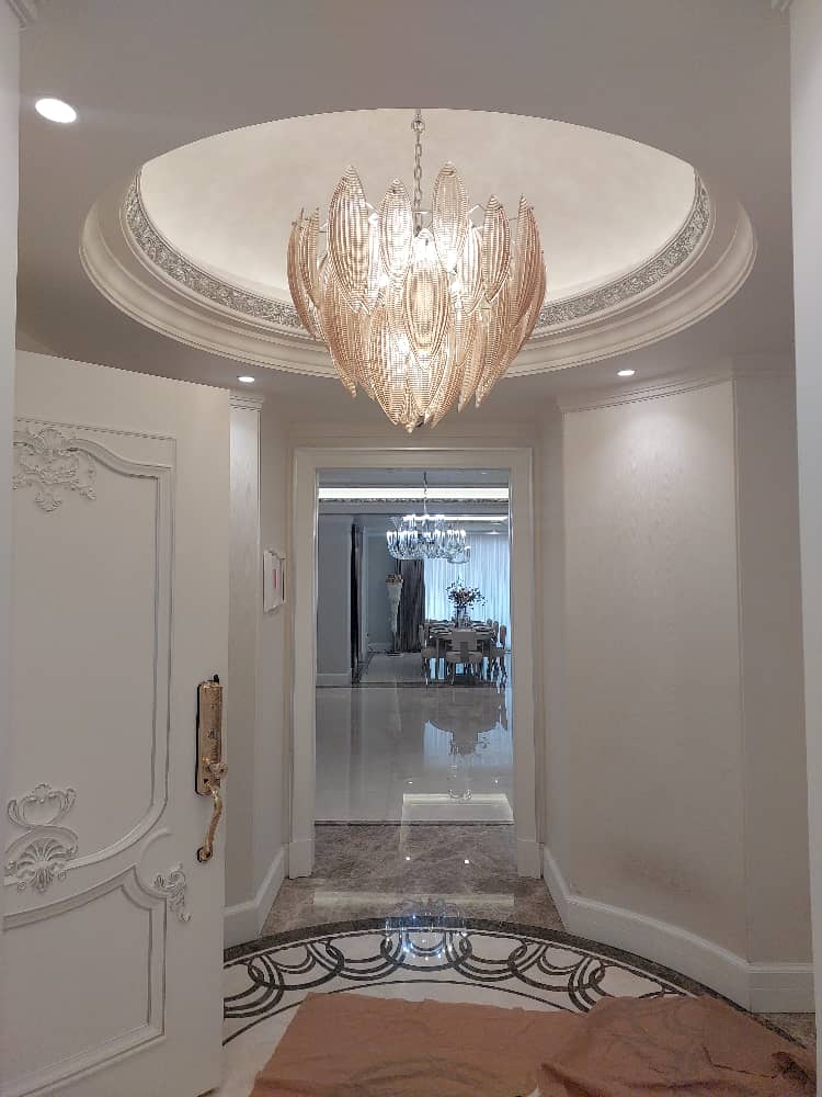 Luxurious entrance with a stunning chandelier and modern interior décor, adding elegance to home design.
