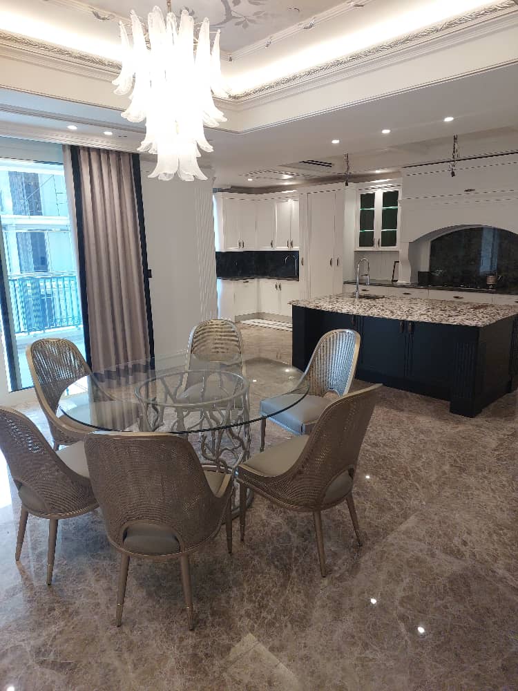 Elegant dining room with a glass table, stylish chairs, and modern chandelier – perfect for contemporary interior design.