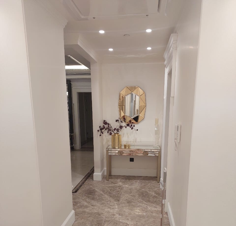 Stylish entrance hallway with a decorative mirror, elegant table, and minimalistic interior design for modern homes.