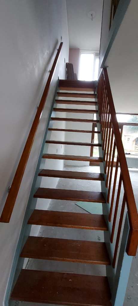 Different staircase renovation projects: wooden staircase, modern stone staircase with beige walls, and concrete staircase with black railing.