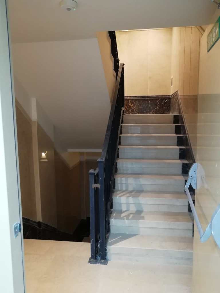 Different staircase renovation projects: wooden staircase, modern stone staircase with beige walls, and concrete staircase with black railing.