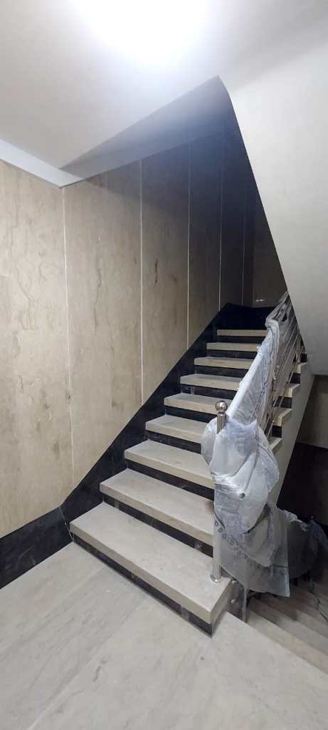 Different staircase renovation projects: wooden staircase, modern stone staircase with beige walls, and concrete staircase with black railing.