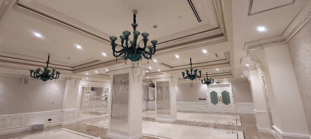 Spacious lobby with marble details, decorative columns, and stylish chandeliers